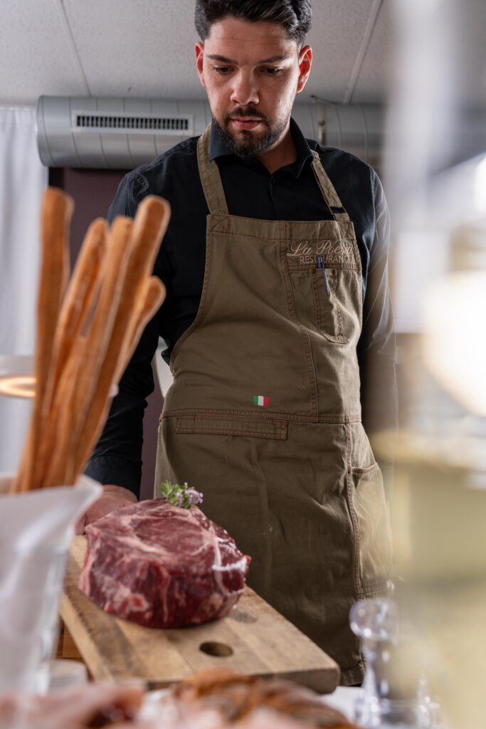 Angelo, responsable de salle qui présente la côte de boeuf à table
